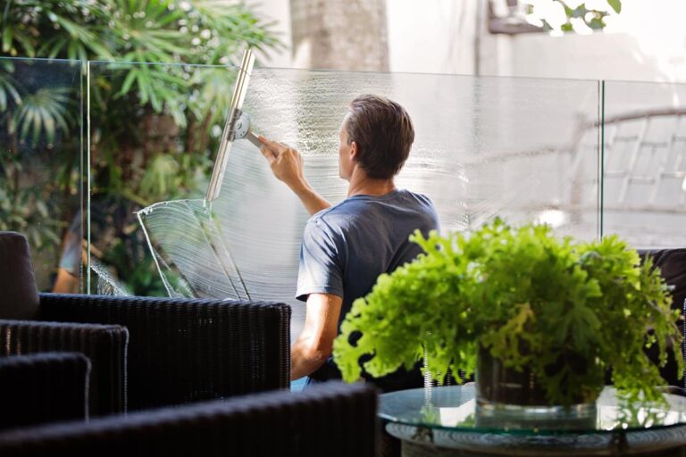 guy cleaning a glass structure in a office setting