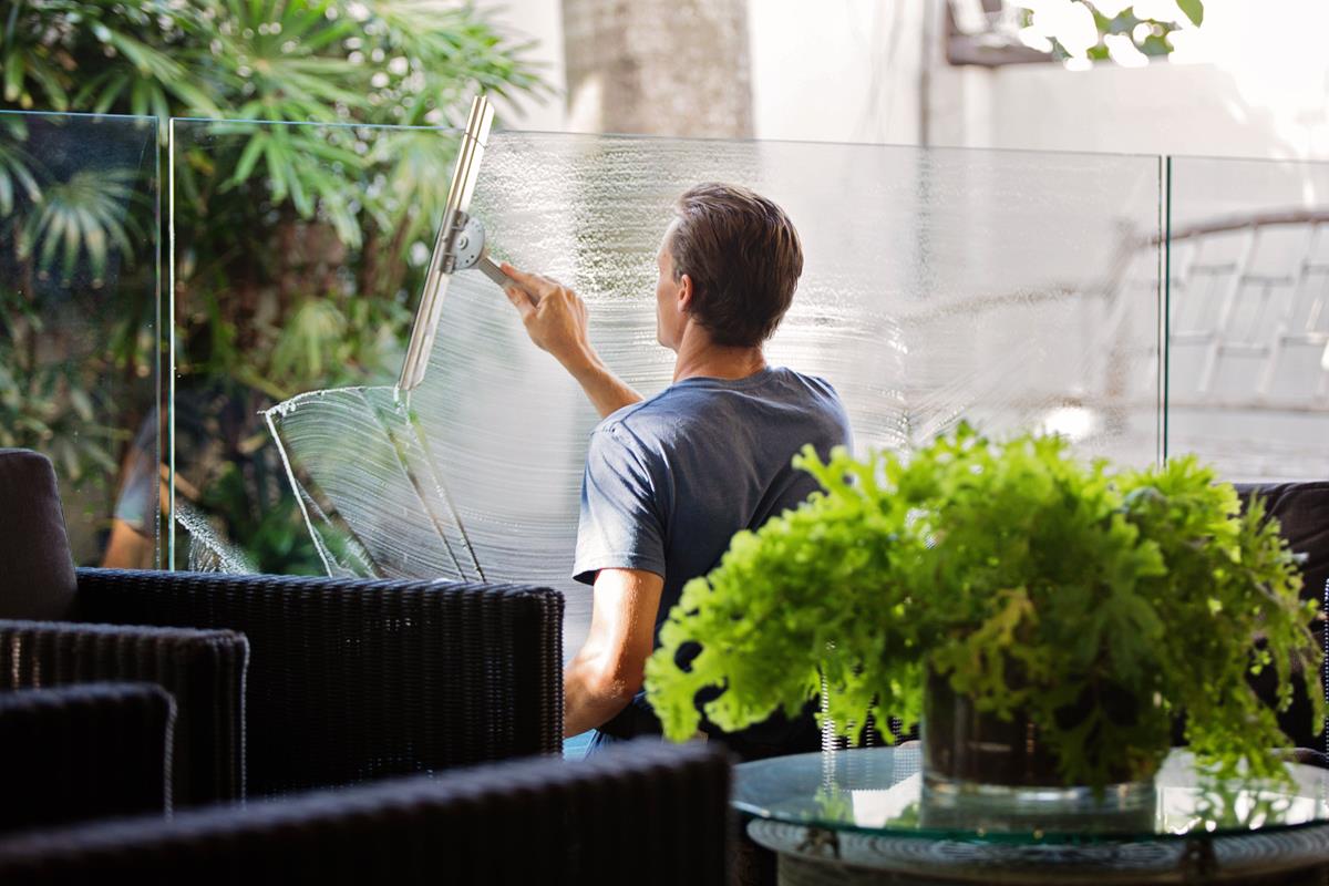 guy cleaning a glass structure in a office setting