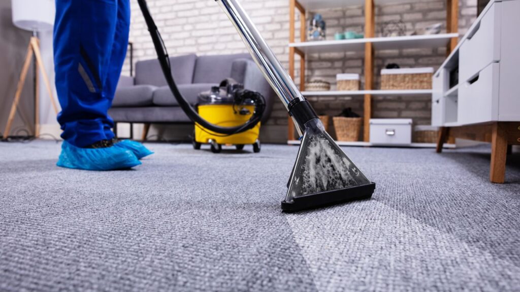 person with proper cleaning clothes, cleaning a carpet in a office
