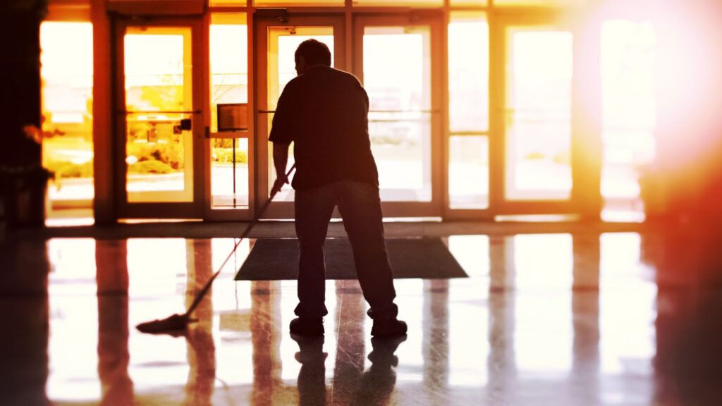 a man mopping a hard floor to optimize cleaning in event centers