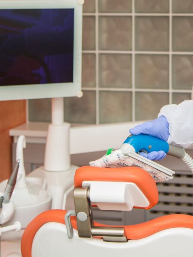 man cleaning a dental office chair with a portable vaccum cleaner