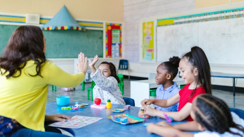 kids-sitting-and-painting-on-classroom-desk