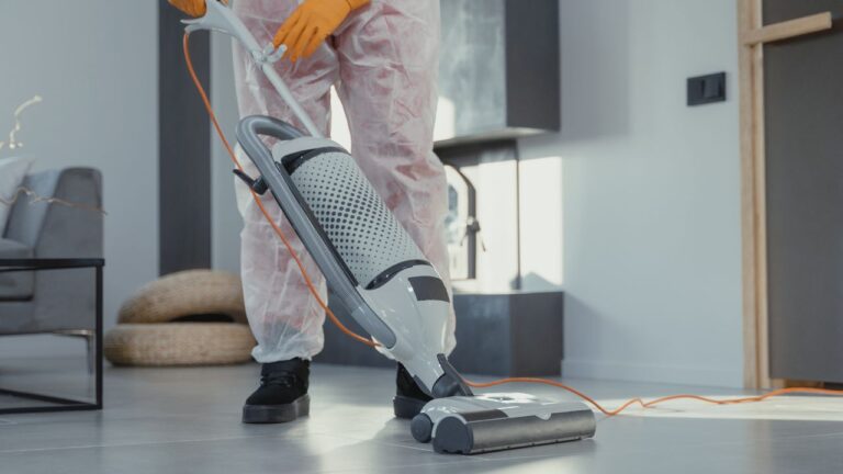 person-with-protective-clothing-vacuuming-a-floor