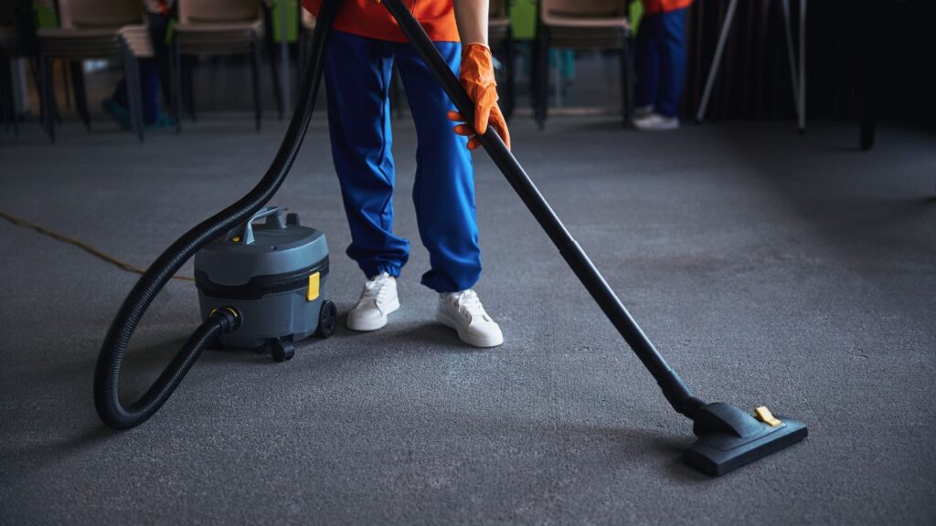 cleaning lady using canister vaccum cleaner
